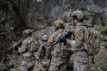 Fototapeta premium Two armed military operators secure an area during a tactical mission, holding rifles while patrolling a dense forest wilderness for defensive strategy, combat readiness, and national security.