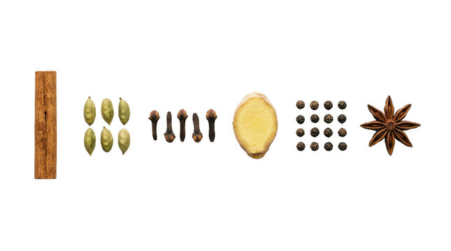 A collection of aromatic dried spices including cinnamon stick cardamom cloves ginger slice and star anise