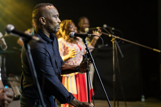 Black male singer performing gospel music live on stage