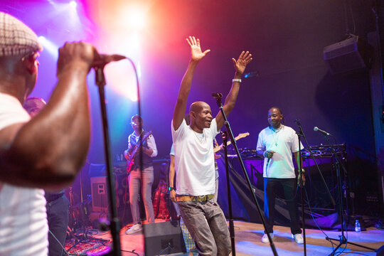 African performer raising hands celebrating on stage