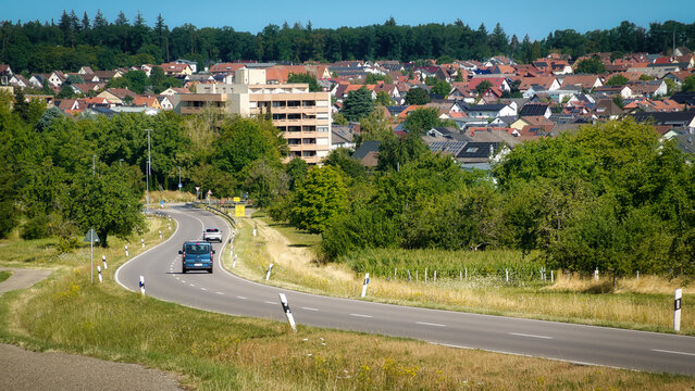 Eine l&auml;ndliche Szene mit einer kurvigen Stra&szlig;e, die hin zu dem Ort Huchenfeld, einem Stadtteil von Pforzheim in Baden-Wuerttemberg, Deutschland f&uuml;hrt