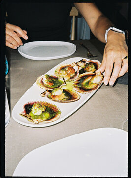 Person enjoying gourmet grilled scallops with herb butter
