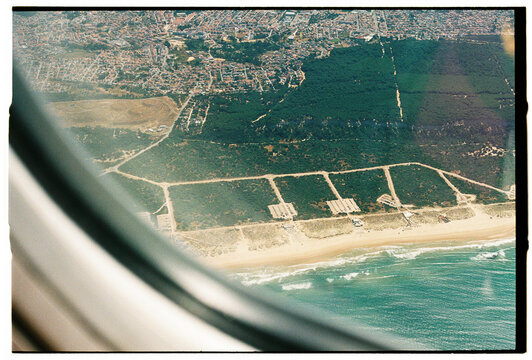 Aerial Coastal City and Beach Seen Through Airplane Window