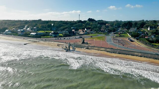 Historic D-Day landing beach at Omaha Beach in Normandy, France, with Les Braves monument near shoreline. Aerial coastal view