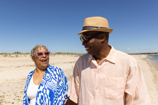 Senior Black Couple laugh walk beach 
