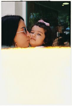 Mother Kissing Daughter with Vintage Film Burn Light Leak Effect