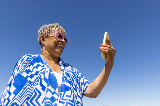 Senior Black Couple cell phone beach 