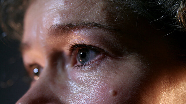 Tr&auml;nenfeuchtes Auge einer &auml;lteren Frau in emotionaler Nahaufnahme