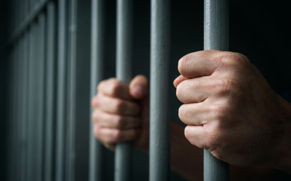 Hands Gripping Prison Bars Imprisonment and Criminal Justice Concept