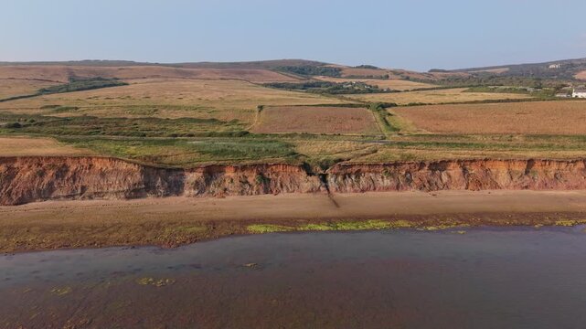 Aerial drone footage of Compton Bay and Brook Chine Beach on the south-west coast of the Isle of Wight, England, showcasing dramatic cliffs, golden sands, turquoise water, and the spectacular coast