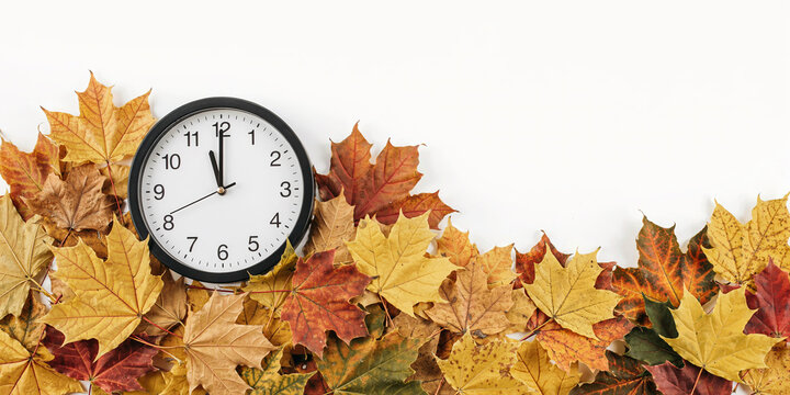 Wall Clock with Autumn Leaves Fall Time Change Concept