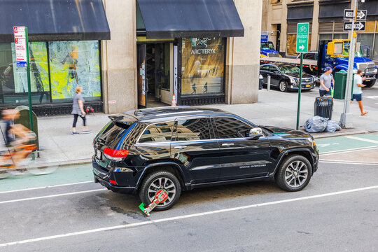 Close-up view of black Jeep Grand Cherokee with police wheel clamp for illegal parking. New York. USA. 