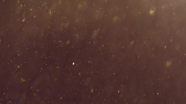Bokeh leak twirl. Flare glimmer. Yellow gray whirl mixing flow. Golden shimmering light color particles on dark abstract background.