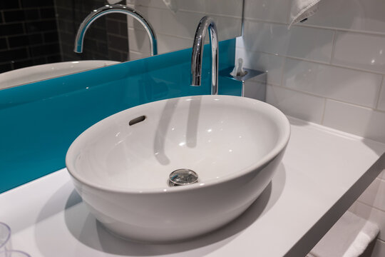 Modern bathroom sink design in a bright space with a blue backsplash and clean water faucet