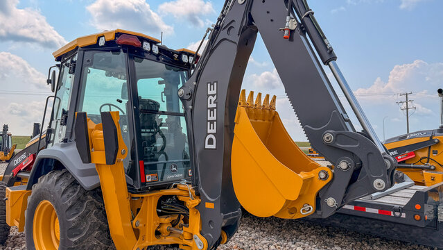 Regina, Canada - July 20, 2026: John Deere backhoe loader with yellow excavator bucket and cab closeup at equipment dealership lot