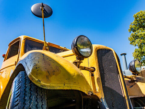 Close up view of headlight on vintage car showing shine and details at classic car show in bright indoor setting