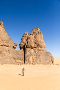 Figure Dwarfed by Twin Desert Pinnacles