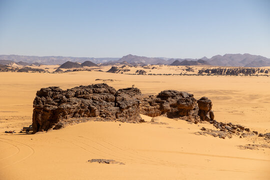 Dark Rock Formation With Mountain Backdrop