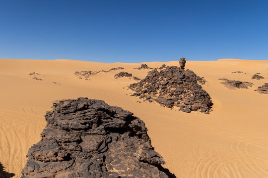 Guide Standing Atop a Distant Rock Formation