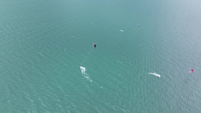 Kite surfing at Lake Garda in Italy during a sunny day with strong wind and clear water