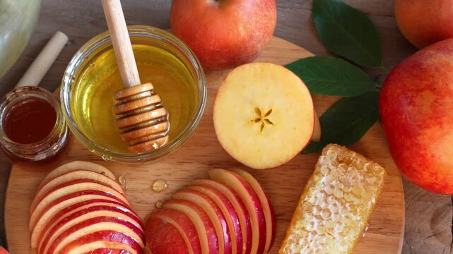 Happy Rosh Hashanah. Jewish New Year holiday concept. Slow rotation of honey, apples and pomegranates, top view, close up. 