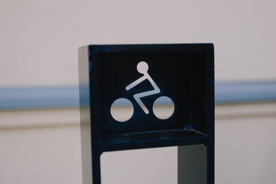 Bicycle parking rack with cyclist symbol outdoors near waterfront