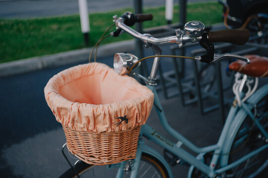 Vintage city bicycle with wicker front basket parked outdoors in urban bike parking area
