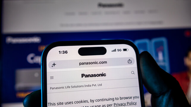 Smartphone displays panasonic website, close up view of technology company branding and website interface.