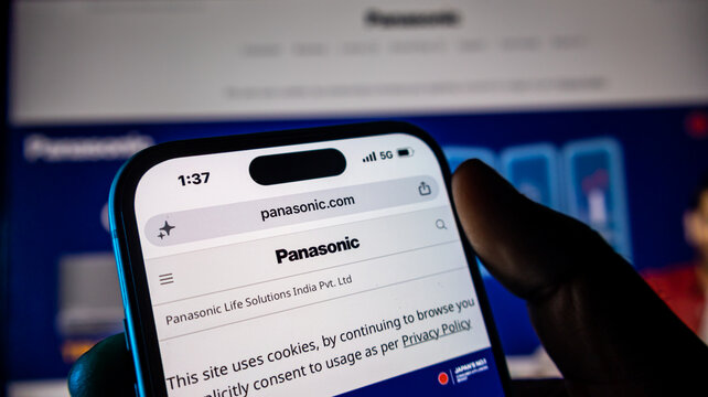 Close up smartphone showing panasonic website, hand holding device, electronic company online presence.