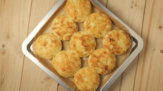 Freshly baked farmer cheese pancakes rotating on a wooden table