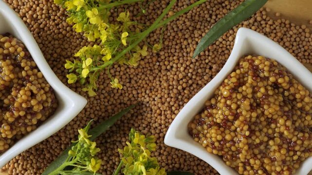 Wholegrain mustard seeds with yellow flowers