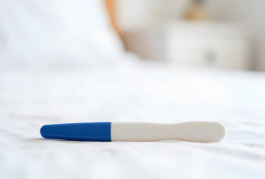pregnancy test on white bed in bright bedroom