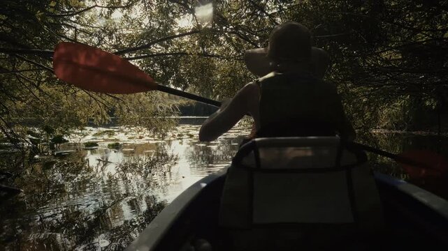 Kayaker Paddling In Kayak On Calm River Water With Water Lilies. Scenic Nature. Summer Journey