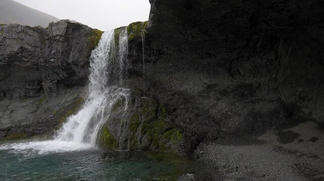 View of a waterfall from inside a rocky cave in Iceland 4K nature footage
