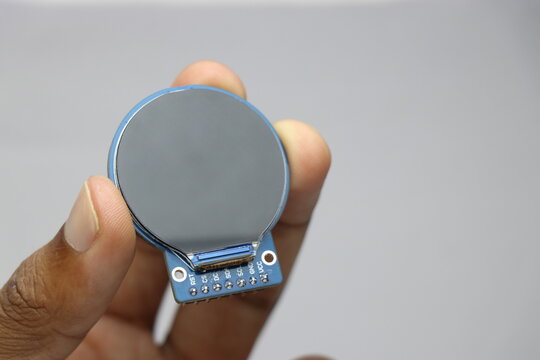 TFT LCD of round shape held in the hand. Digital LCD screen display for electronics