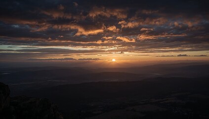 Fototapeta premium Stunning golden sunrise over a vast horizon with dramatic clouds.