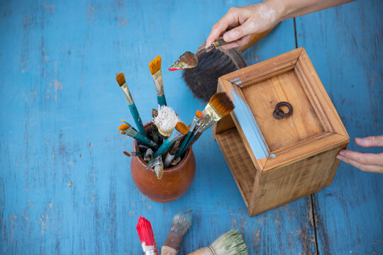 Painting a wooden furniture outdoors, an eco-friendly re-use business.