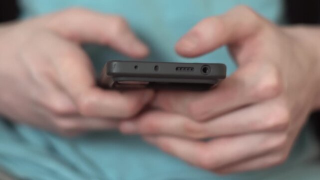 A woman is holding a smartphone while sitting comfortably. The smartphone displays various features and functions, highlighting its modern design and usability.