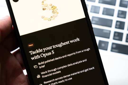 Warsaw, Poland - July 26, 2026: Opus 5 AI assistant interface displayed on smartphone screen showing features for data analysis and document creation on desk near keyboard