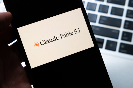Warsaw, Poland - July 26, 2026: Claude Fable 5.1 AI model branding displayed on smartphone screen held in hand against laptop keyboard background