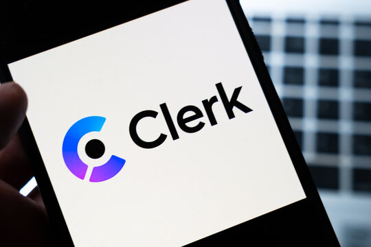 Warsaw, Poland - July 26, 2026: Clerk authentication platform logo displayed on smartphone screen held in hand against blurred urban building background