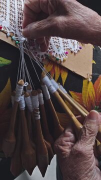 Bobbin lace. A traditional lacemaker creates lace using a traditional process introduced by Azorean settlers; a handicraft available for sale in the historic center of Florianópolis vertical 4k