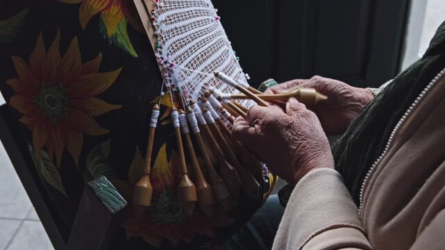 Bobbin lace. A traditional lacemaker creates lace using a traditional process introduced by Azorean settlers; a handicraft available for sale in the historic center of Florianópolis 