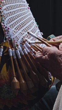 Bobbin lace. A traditional lacemaker creates lace using a traditional process introduced by Azorean settlers; a handicraft available for sale in the historic center of Florianópolis vertical 4k