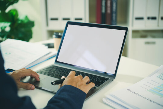 Business professional using laptop with blank screen and financial reports to analyse performance review break-even data improve budgeting and support strategic decision making.