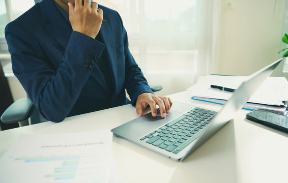 Financial decision making with business professional using laptop and reports to evaluate performance solve budget challenges reduce risk and support strategic planning.