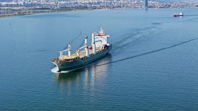 Dry cargo ship sailing in bay water. Import export logistics and global cargo transportation concept in real maritime setting