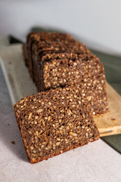 Sliced Nordic sourdough rye bread on a wooden cutting board.