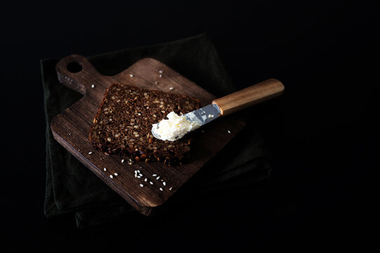 Cream cheese on a slice of seeded Danish rye bread.