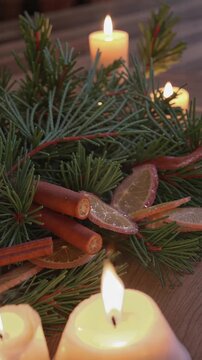 Christmas candles with pine branches and cinnamon, vertical